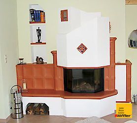 In der Ecke des Zimmers steht ein Kamin.