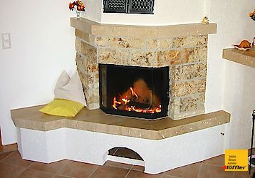 In der Ecke des Zimmers steht ein Kamin.