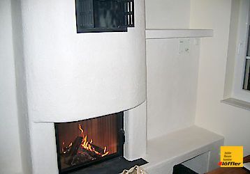 In der Ecke des Zimmers steht ein Kamin.