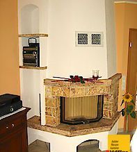 In der Ecke des Zimmers steht ein Kamin.