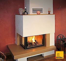 Ein Kamin mit einer Flasche Schnaps darauf in einem Wohnzimmer.