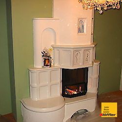 Ein weißer Kamin mit einem Kronleuchter, der in einem Wohnzimmer von der Decke hängt.