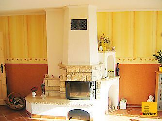 Ein Wohnzimmer mit Kamin und gelben Wänden