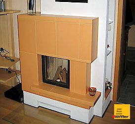 Ein Kamin in einem Wohnzimmer mit einem gelben Schild mit der Aufschrift „Hoffler“