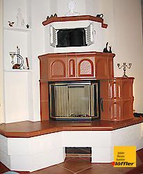 In der Ecke des Zimmers steht ein Kamin.