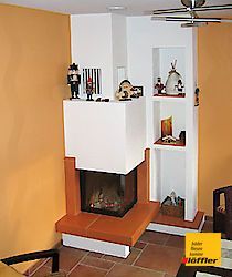 Ein Wohnzimmer mit Kamin und Deckenventilator.