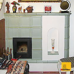 Ein Wohnzimmer mit Kamin und einer Vase auf dem Regal.