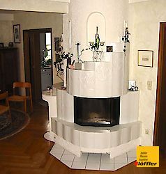 In der Ecke des Zimmers steht ein Kamin.