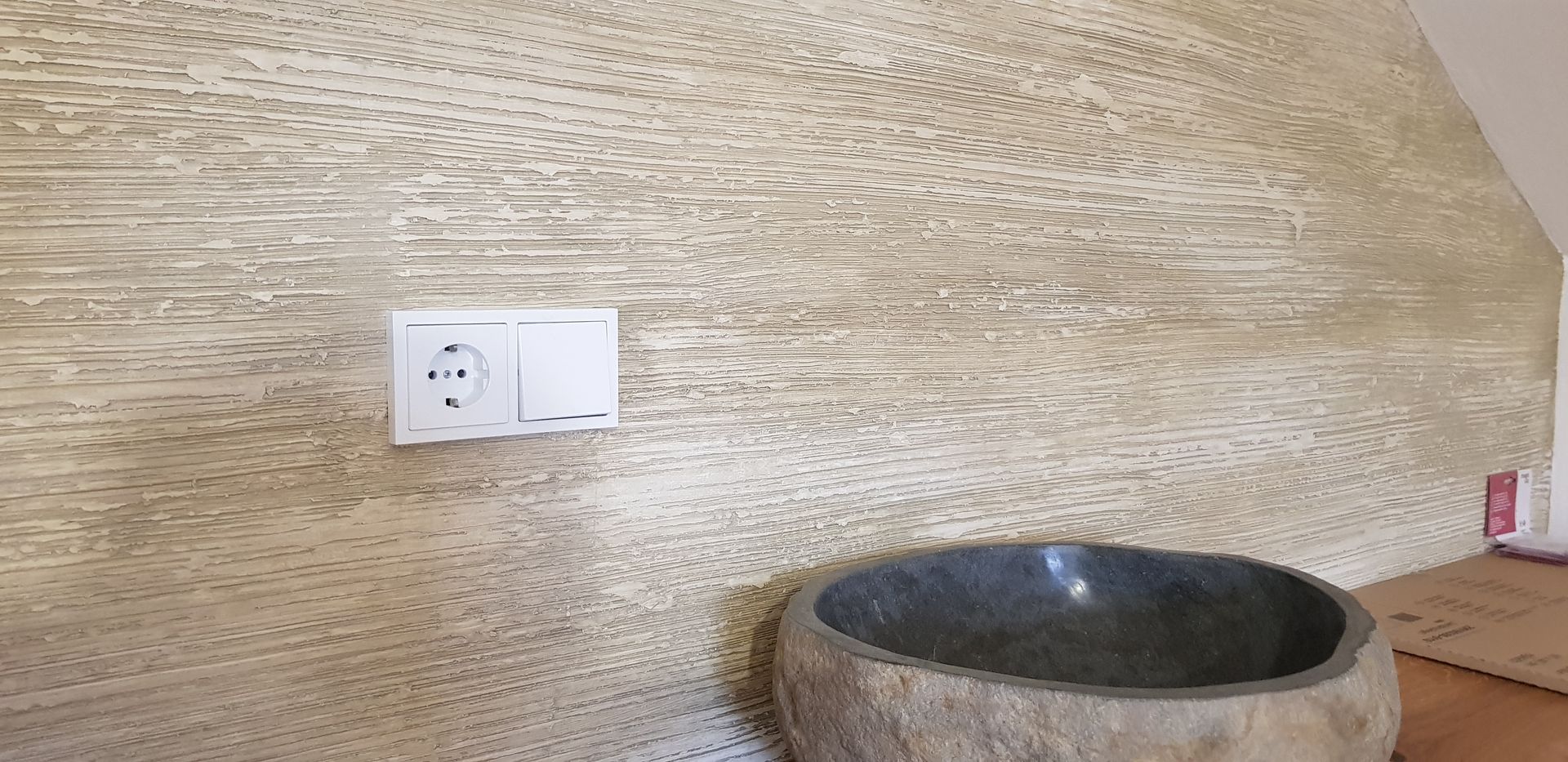 Waschbecken aus Naturstein mit hölzerner Rückwand