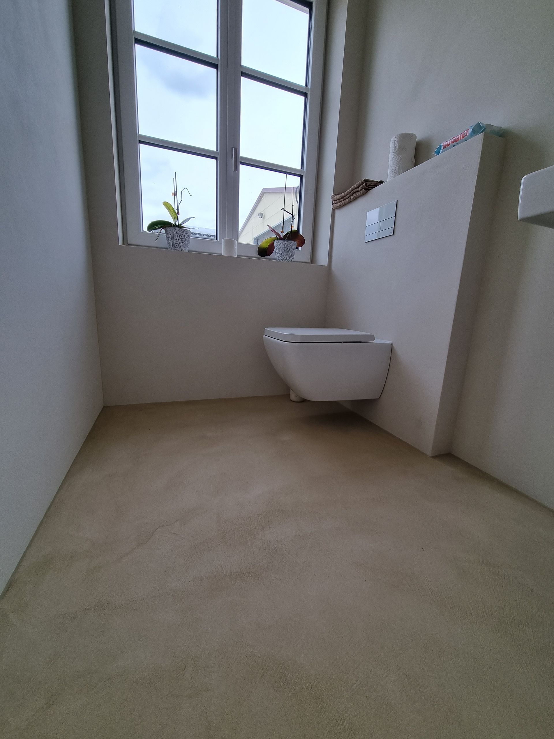 Neu gefliestes, fogenloses Badezimmer mit Steinboden