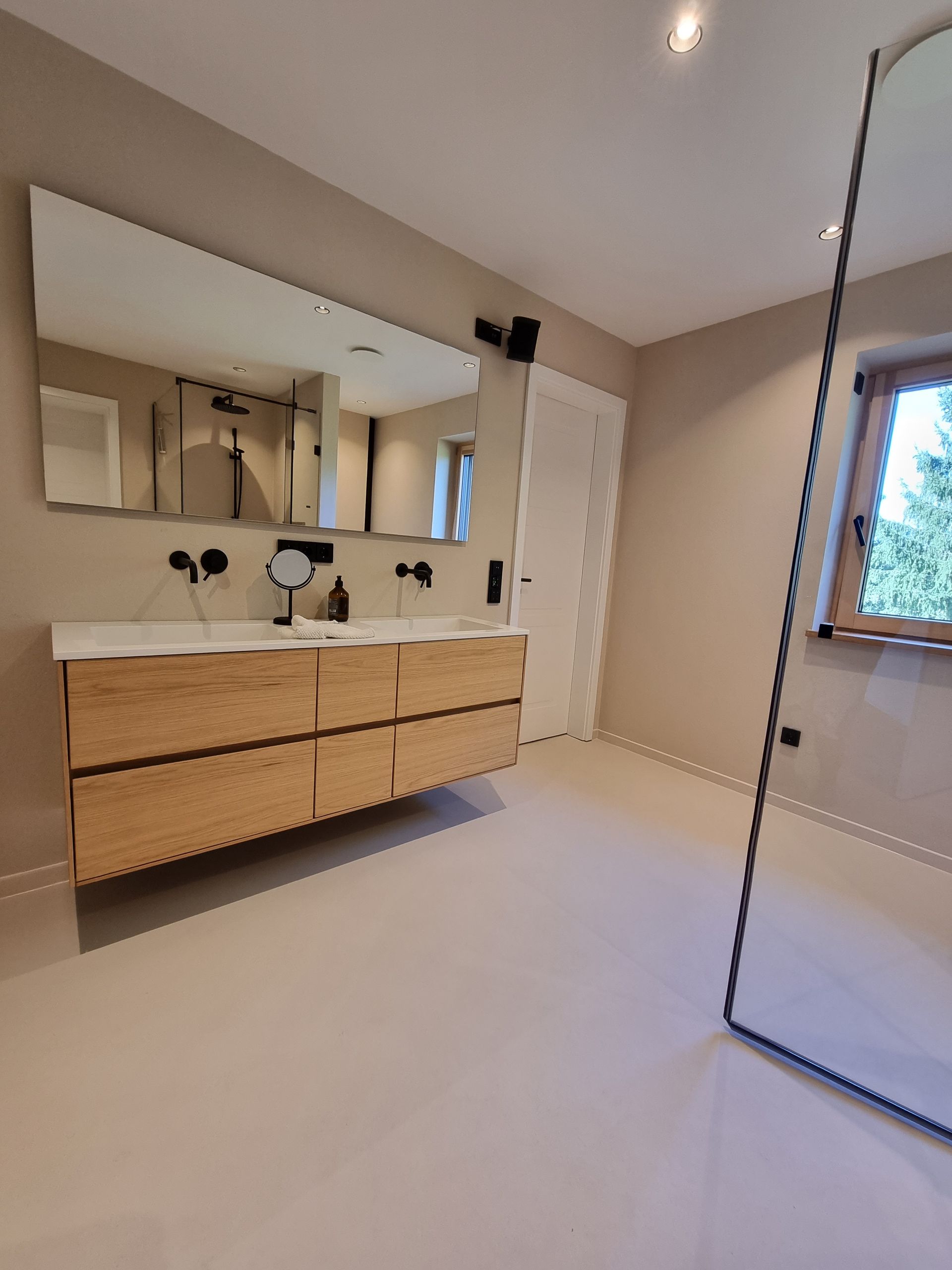 Frisch saniertes Badezimmer mit neuem Schrank, zwei Waschbecken, Spiegelschrank und ebenerdiger Dusche