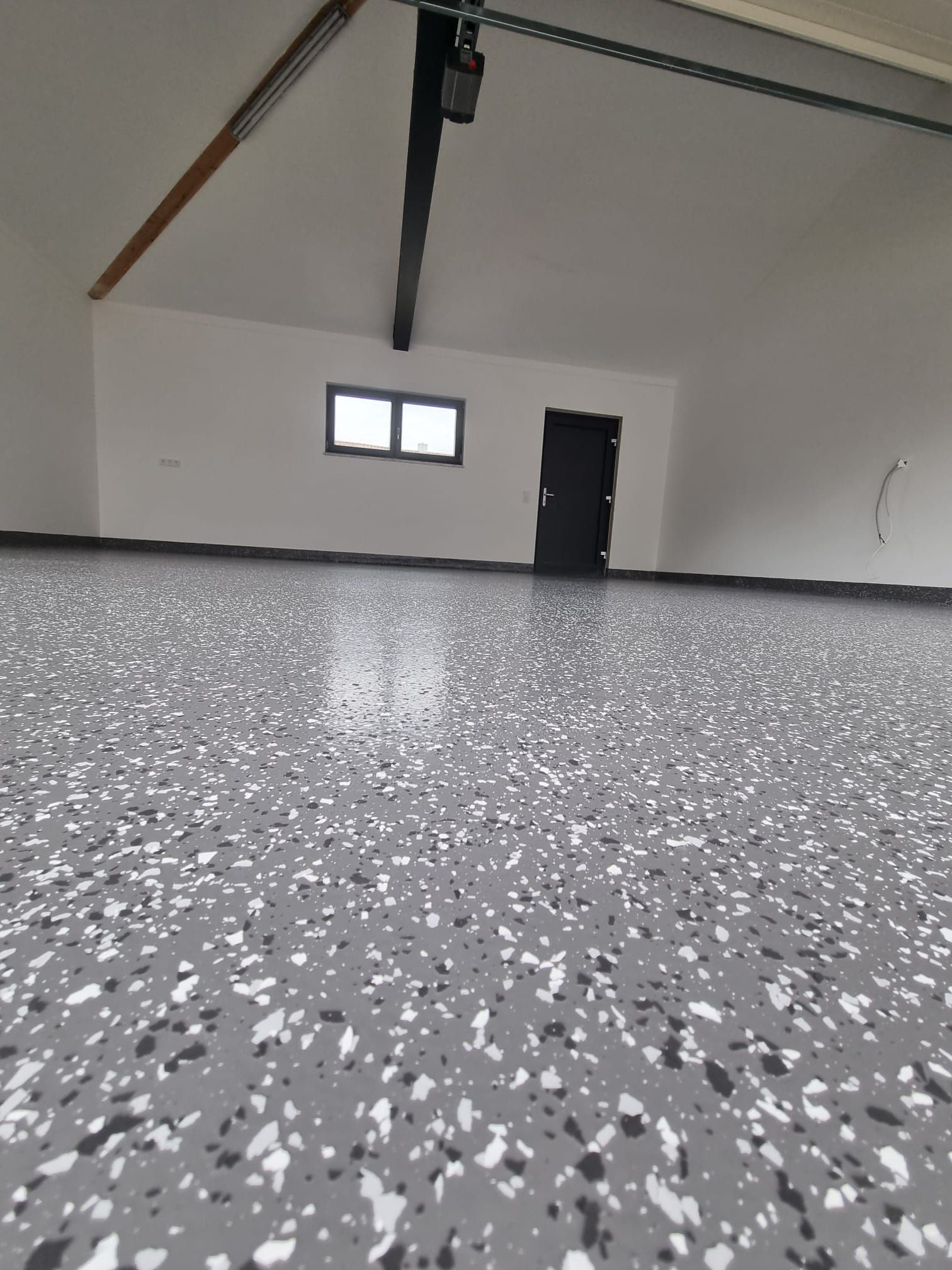 Nahaufnahme eines grau gesprenkelten Bodens mit Spezialbeschichtung in einer Garage