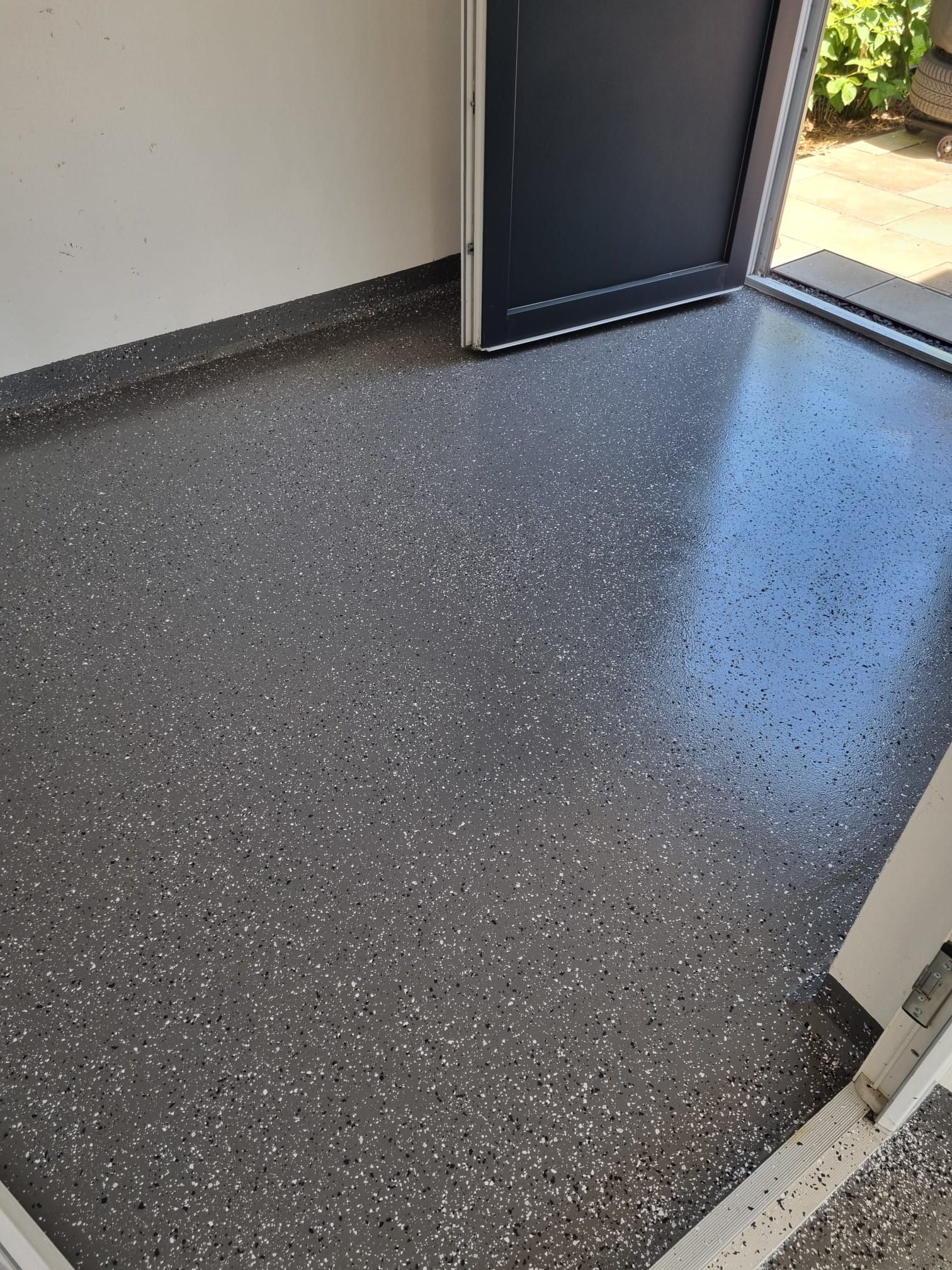 Nahaufnahme eines grau gesprenkelten Bodens mit Spezialbeschichtung in einer Garage