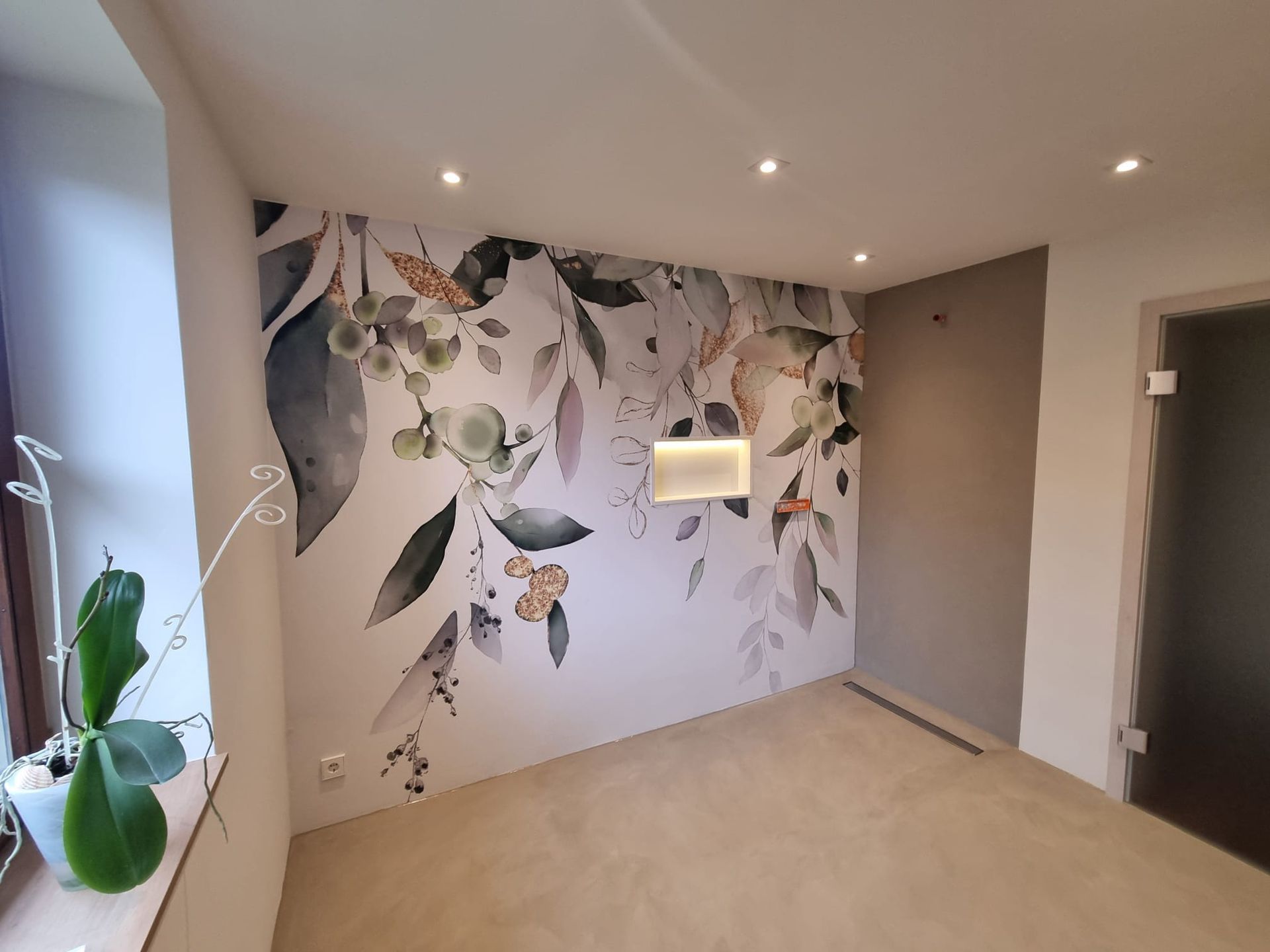 Renovierter Raum mit einer floralen Tapete und in der Wand eingelassener Ablage mit Beleuchtung