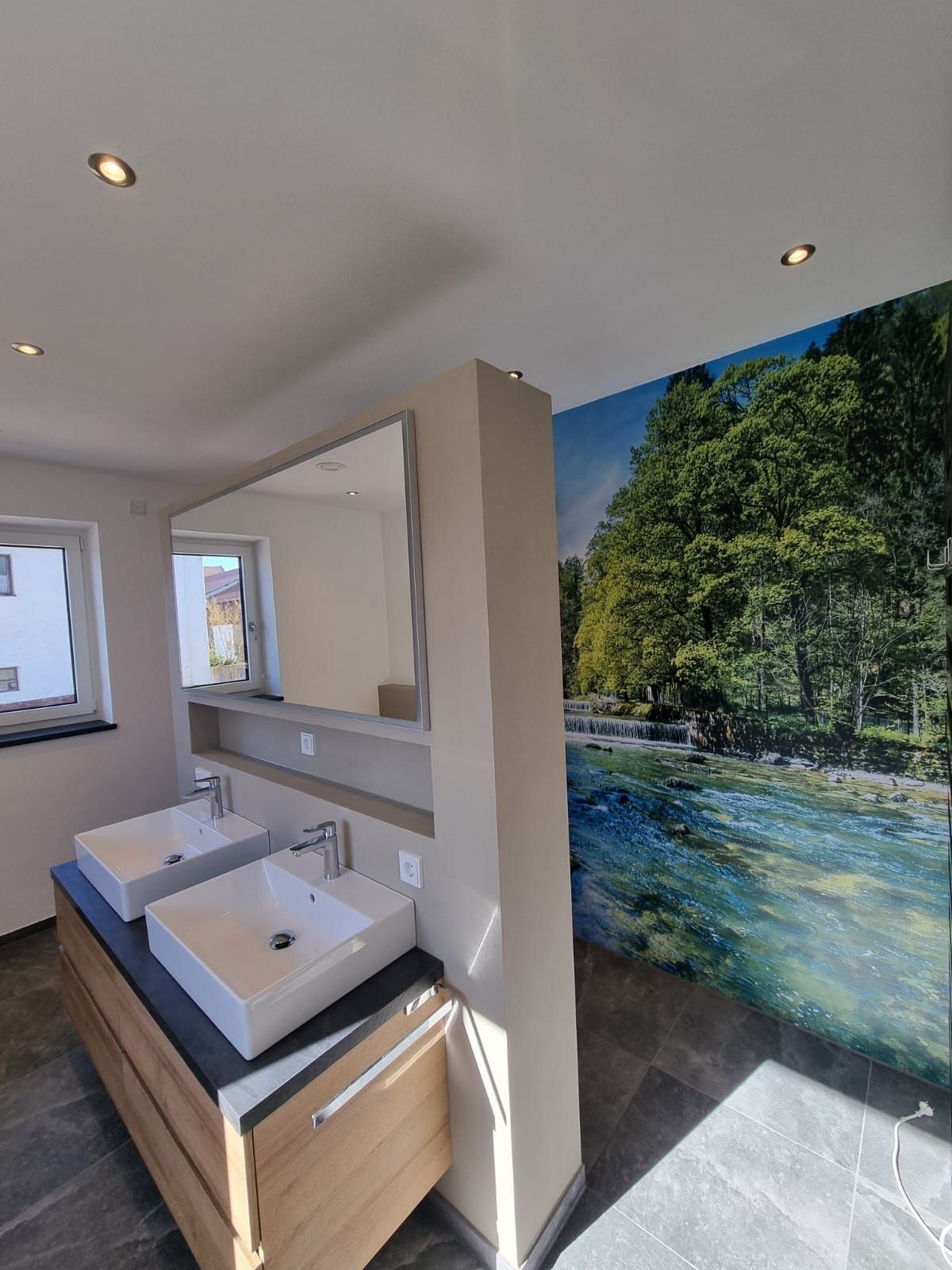 Badezimmer mit einer Natur-Fototapete und zwei eckigen Waschbecken