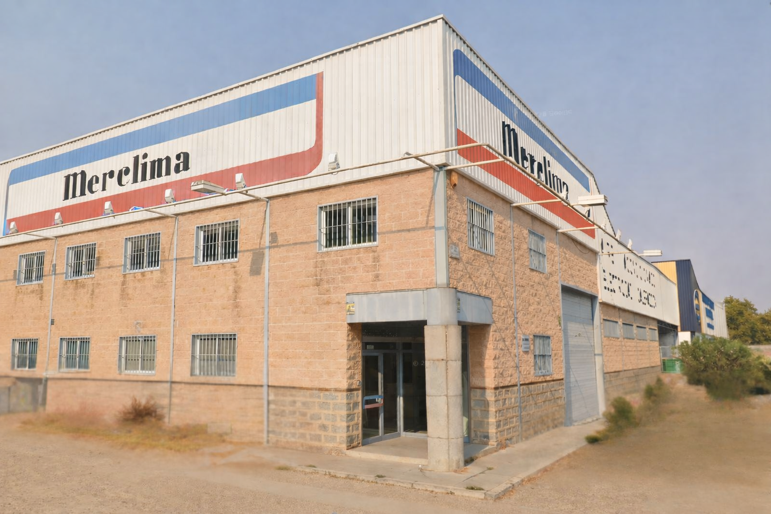 Un gran edificio de ladrillo con un coche aparcado delante.