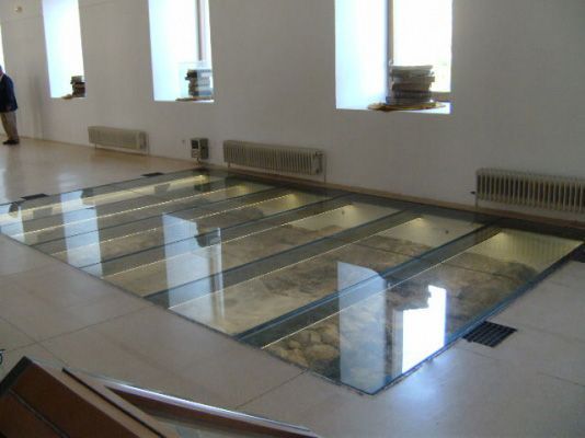 Un hombre está parado en una habitación con piso de vidrio.