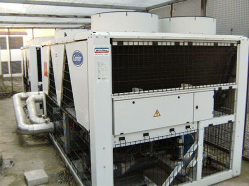 Un gran aparato de aire acondicionado blanco está situado debajo de un techo.