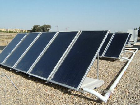 Una fila de paneles solares colocados sobre una superficie de grava.