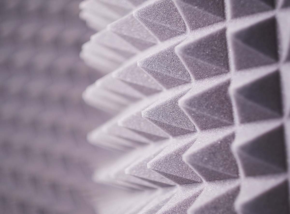 Un primer plano de un material de insonorización en forma de pirámide en una pared.