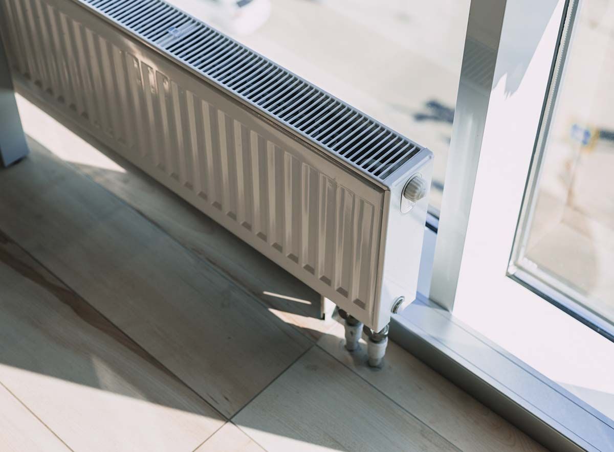 Un radiador está situado al lado de una ventana en una habitación.