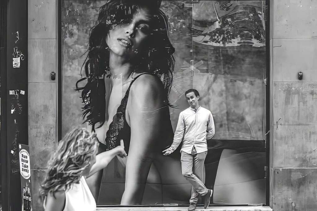 Un hombre pasa junto a un gran mural de moda en blanco y negro en una pared de la ciudad.