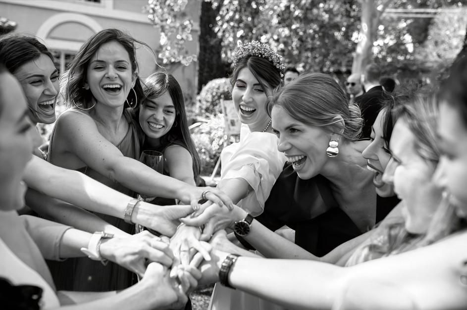 Grupo de personas sonriendo y juntando las manos al aire libre en blanco y negro.