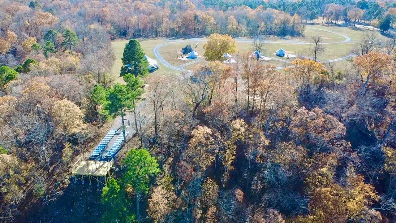 Overhead view of a road leading to buildings in a fall forest.