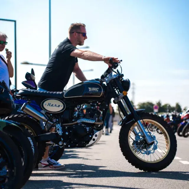 Ein Mann fährt ein Motorrad mit dem Wort „Rear“ auf der Seite