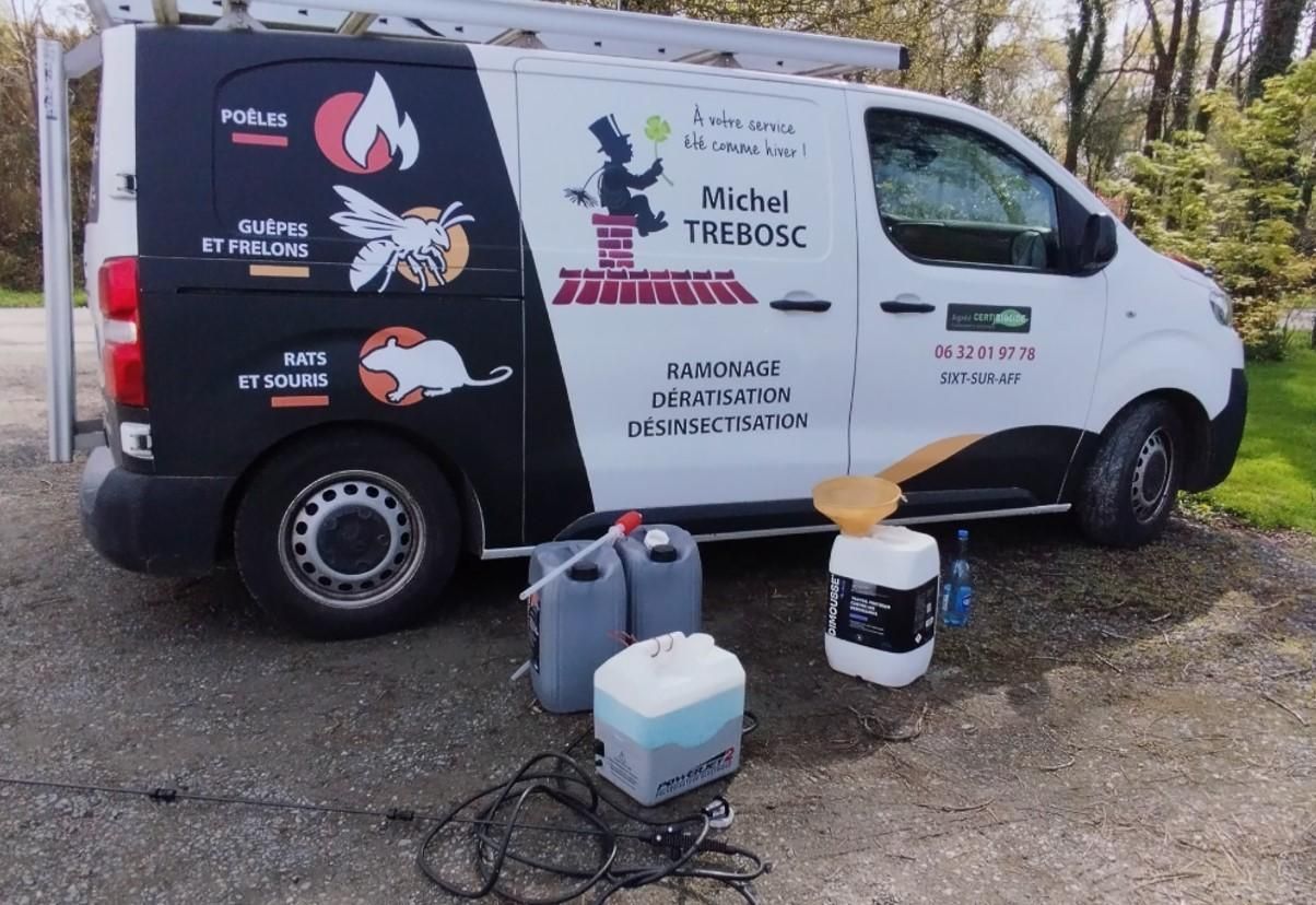 Camion de ramonage avec équipement, stationné à l'extérieur; véhicule noir et blanc.