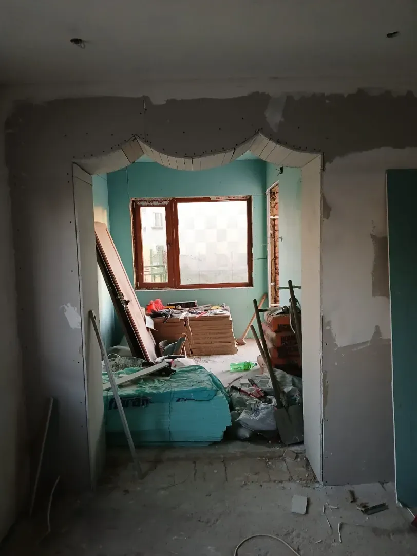 Agujero en un techo rosa, revelando tuberías y un interior luminoso.