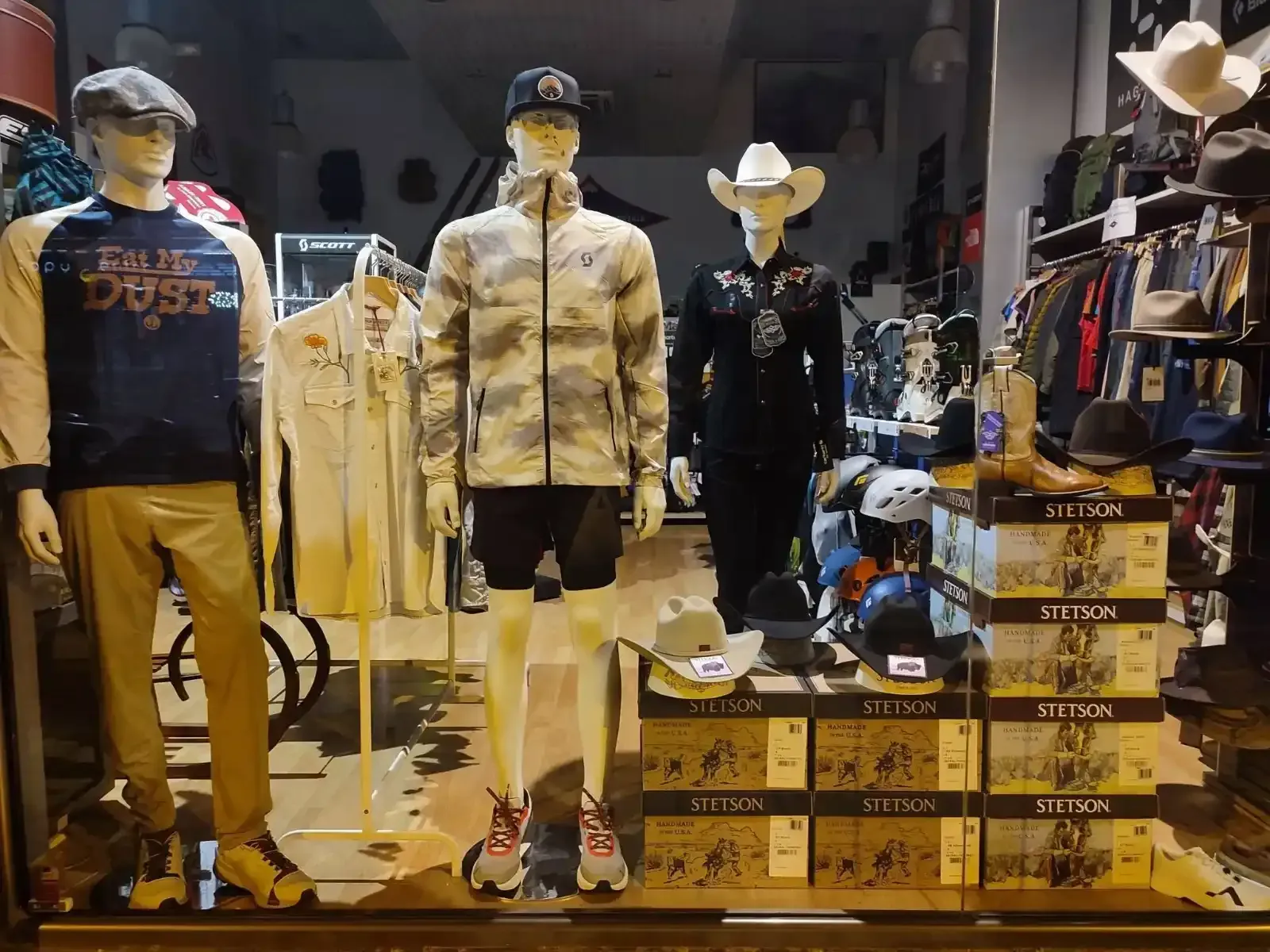 Exhibición de maniquíes con ropa informal, sombreros y zapatillas deportivas en una tienda minorista.