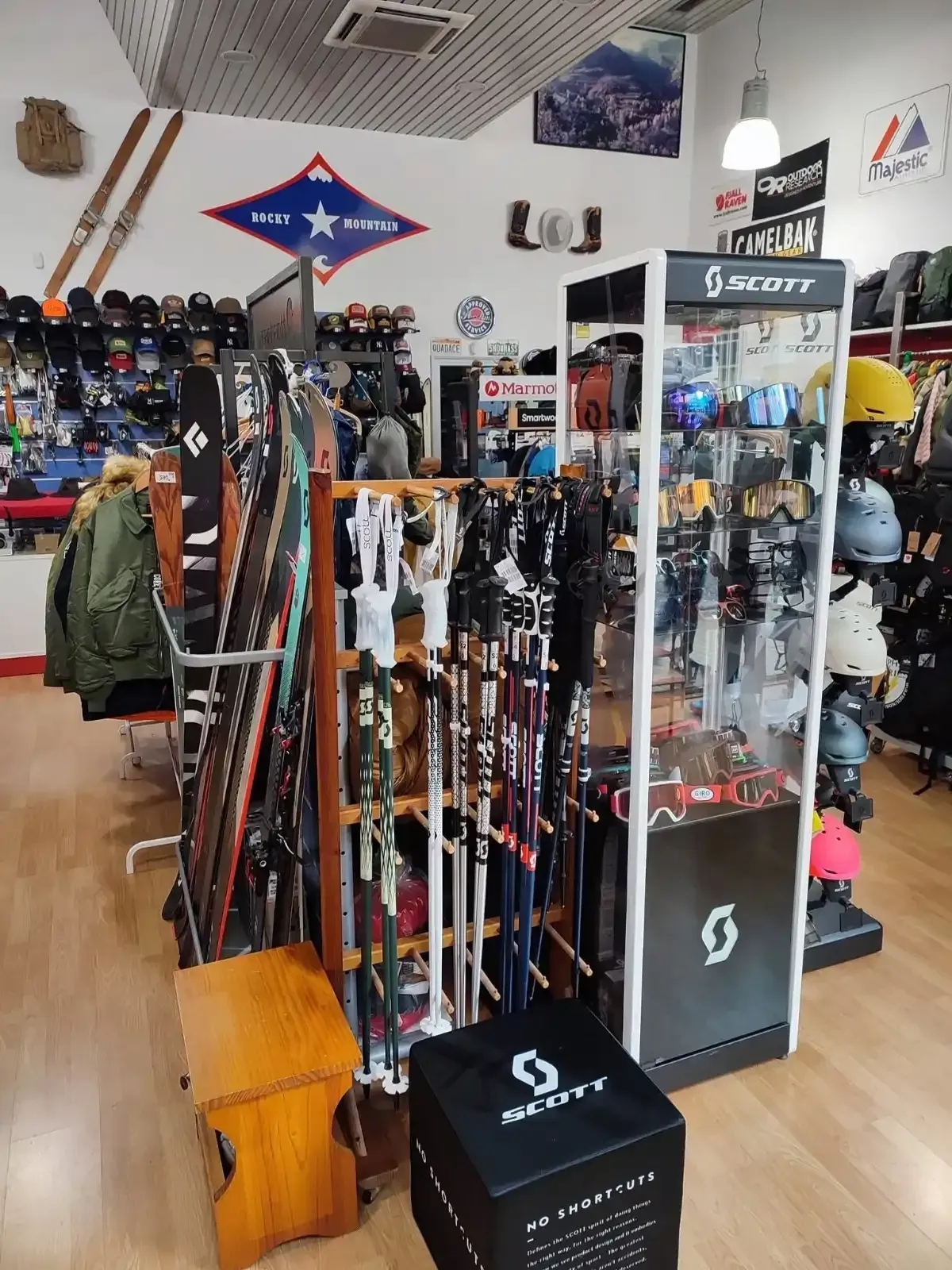 Interior de una tienda de esquí con filas de esquís, cascos y equipo de invierno en exhibición.