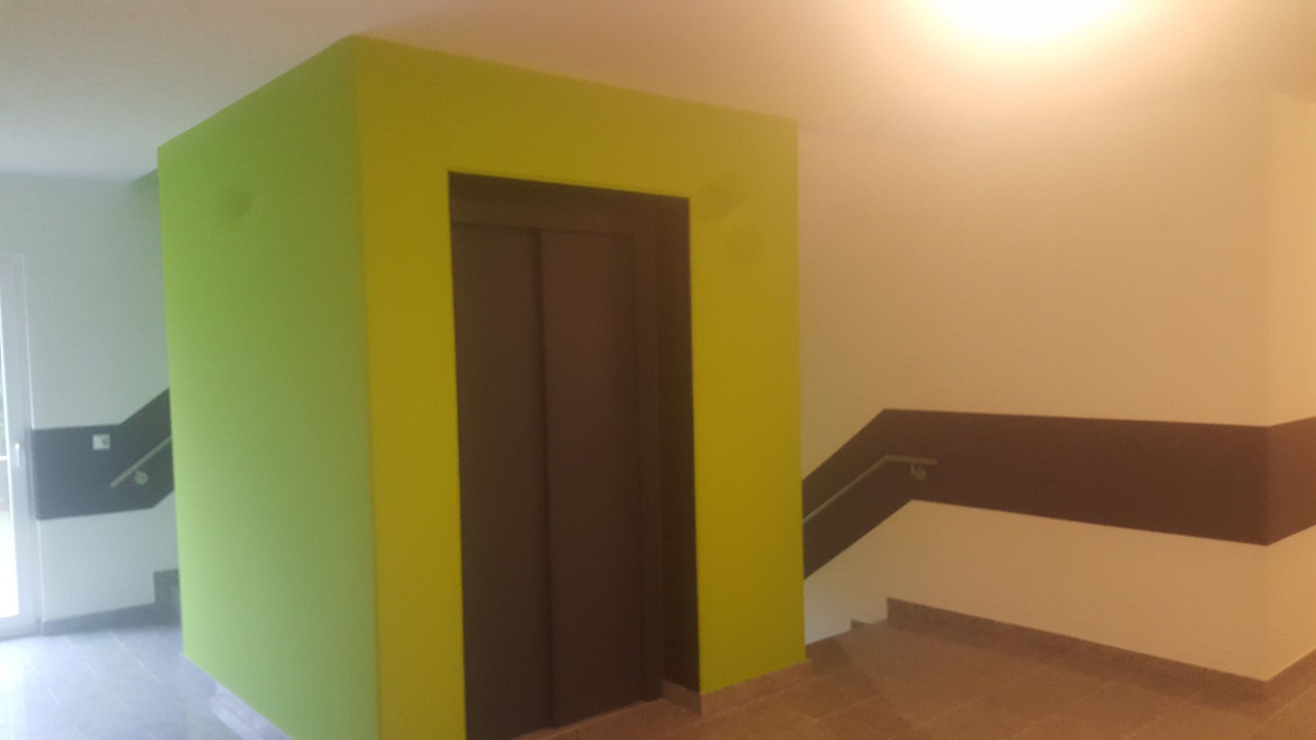 Grün bemalte Wand bei einem Aufzug