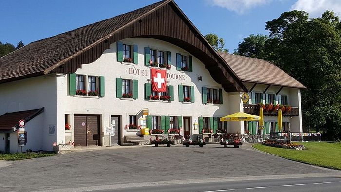 Un grand bâtiment blanc avec un drapeau suisse sur la façade