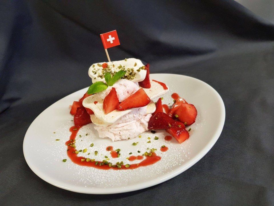 Un dessert avec des fraises et de la crème fouettée sur une assiette blanche