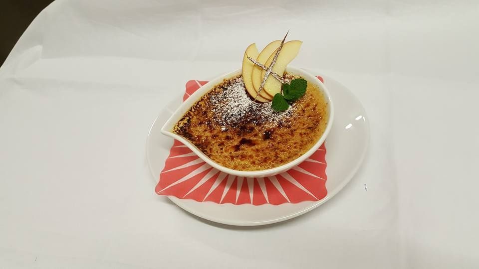 Une assiette blanche surmontée d'un bol de nourriture avec des pommes dessus.