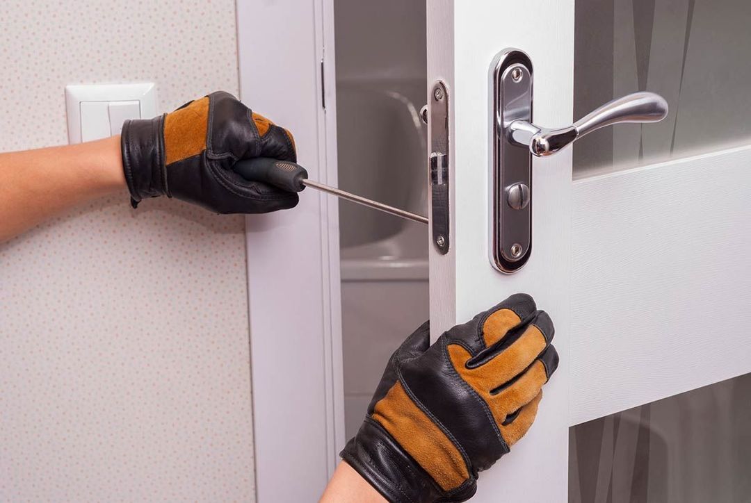 Una persona está arreglando una puerta con un destornillador.