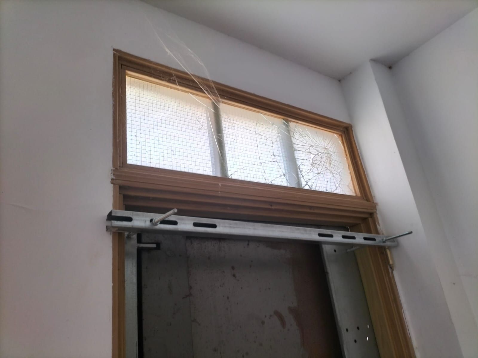 Una pared blanca con una ventana.
