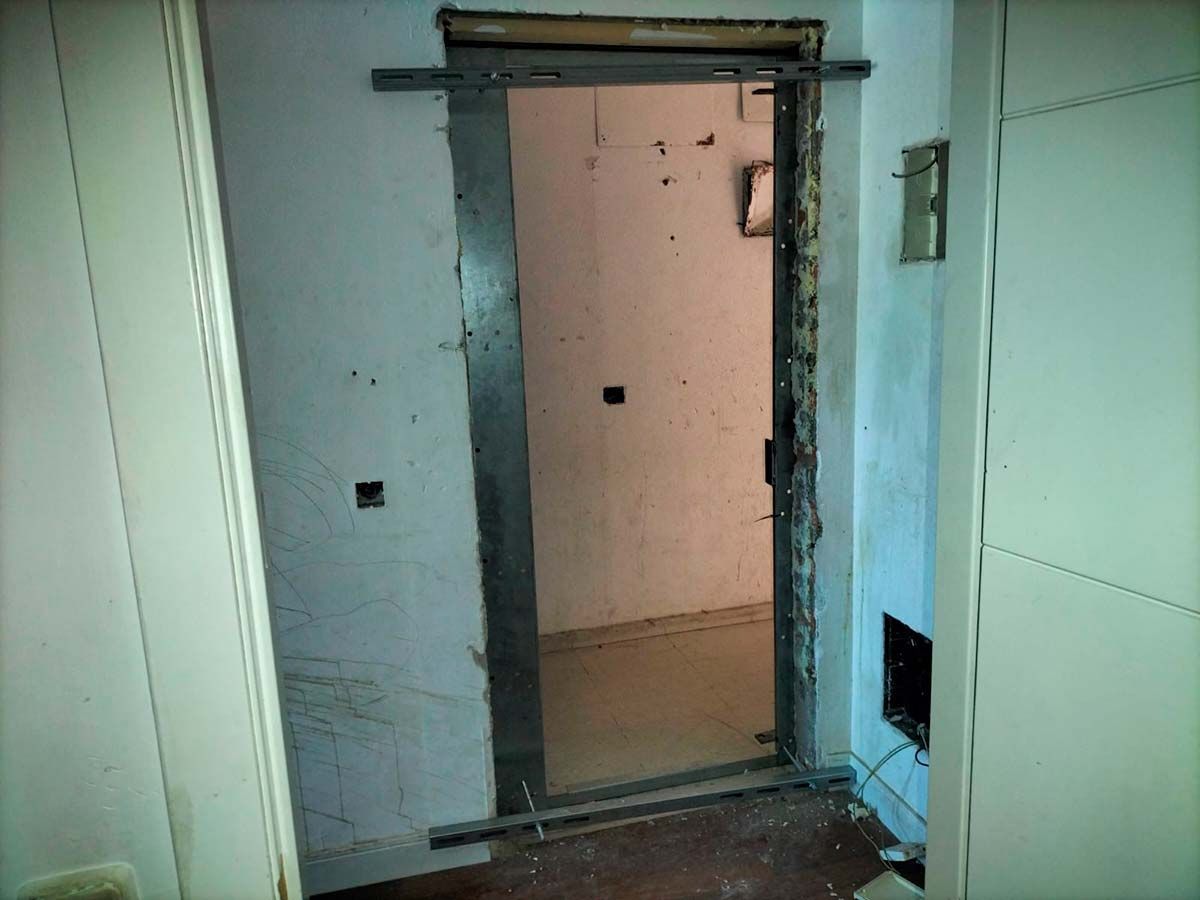 Una puerta está abierta en una habitación con una pared blanca.
