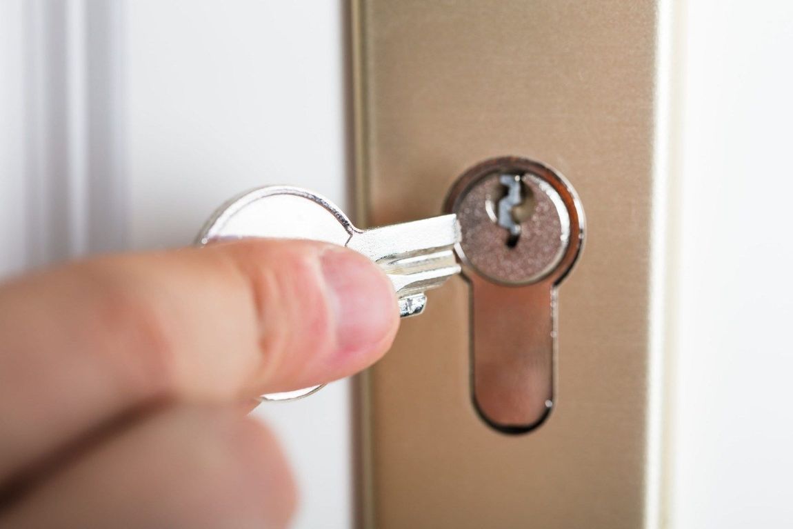 Una persona está arreglando una cerradura de puerta con una llave.