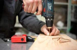 Un martillo, alicates, destornillador, llave inglesa y llave ajustable sobre un fondo blanco.