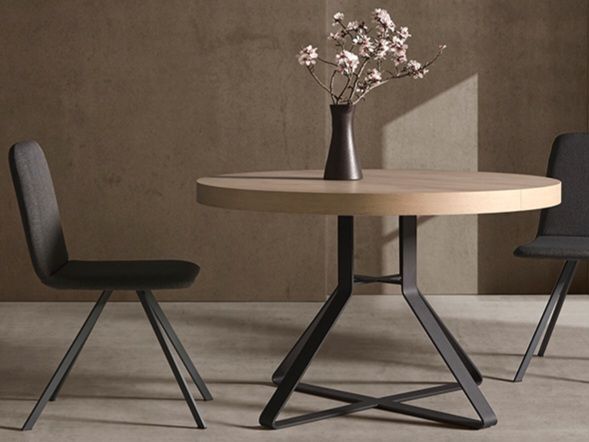 Una mesa de comedor con cuatro sillas y un cuenco encima.