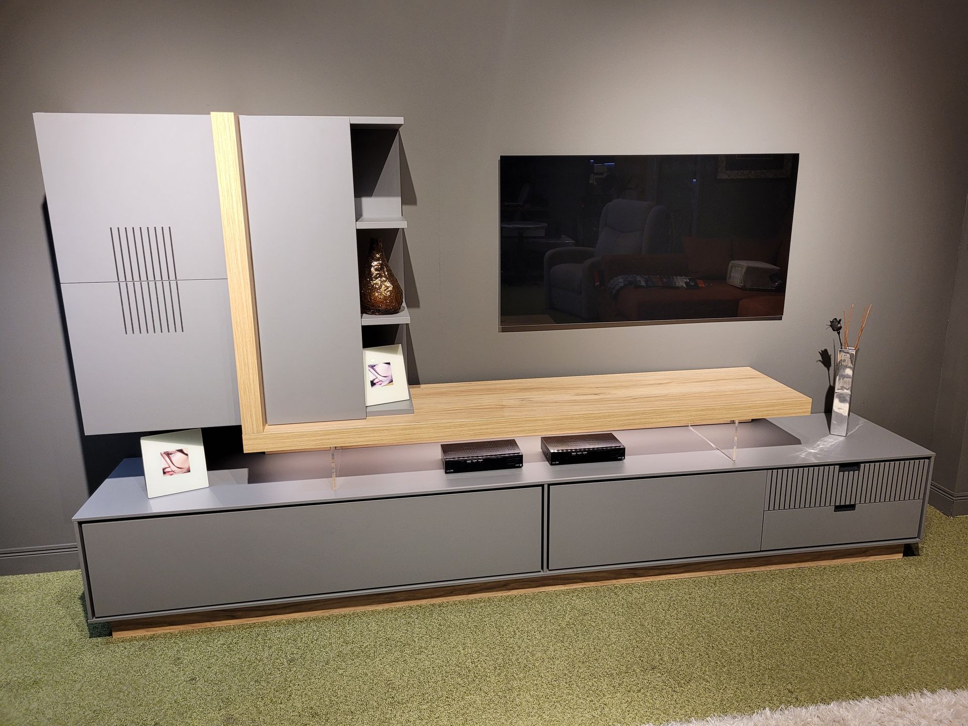 Una sala de estar con un televisor de pantalla plana en la pared.