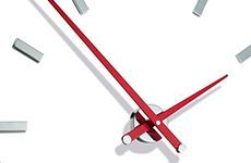 Un primer plano de un reloj con manecillas rojas sobre un fondo blanco.