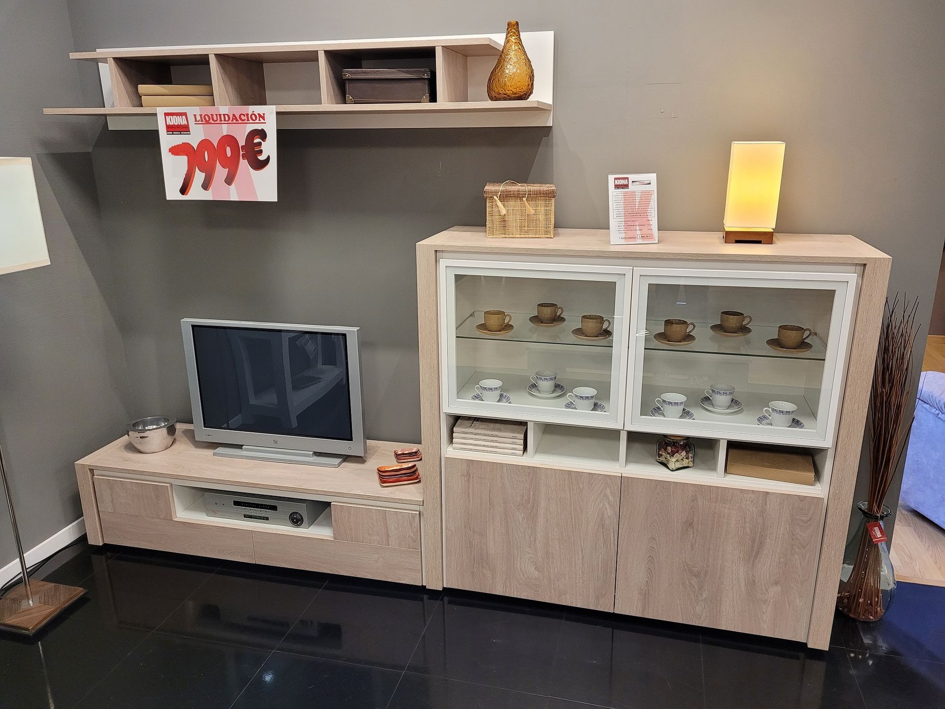 Una sala de estar con un televisor en un soporte.