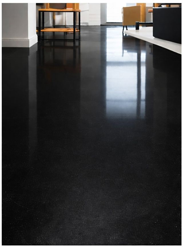 El suelo negro pulido refleja la luz y el mobiliario interior.