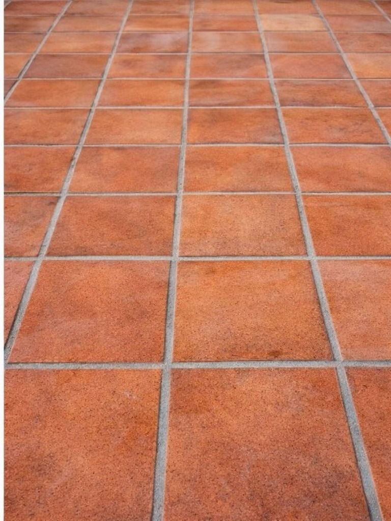 Piso de baldosas de color terracota con líneas de lechada grises.