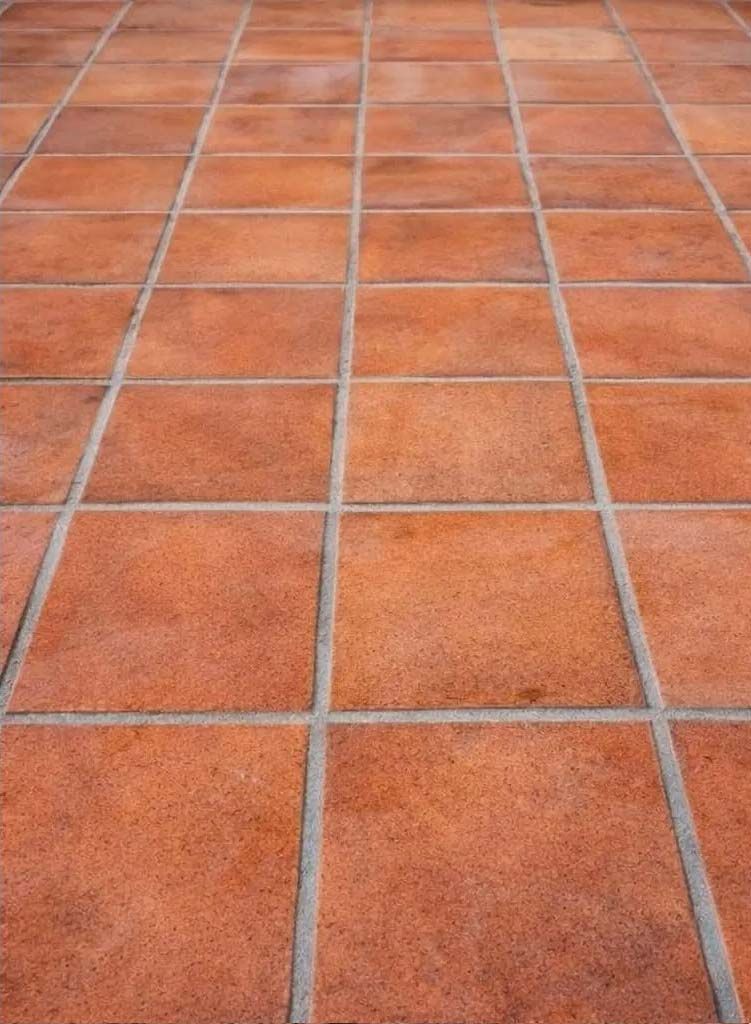 Piso de baldosas de color terracota con líneas de lechada grises.