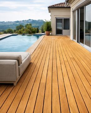 Deck de madera junto a piscina y casa con grandes ventanales, día soleado y luminoso.